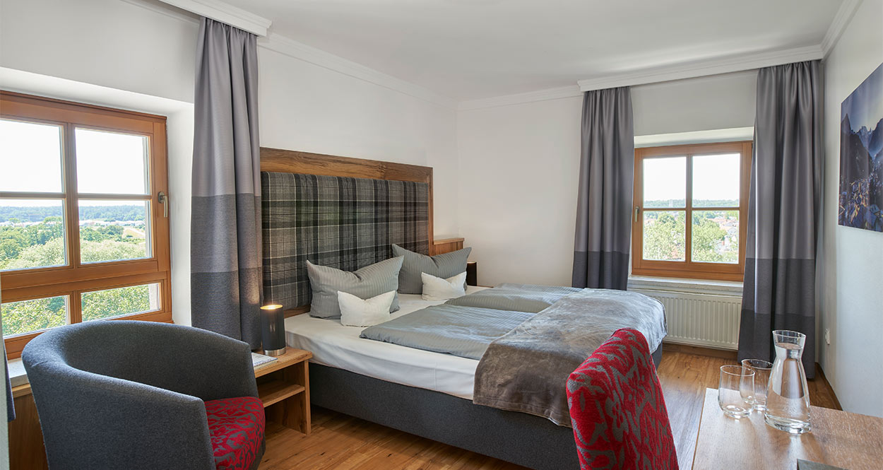 Ein Doppelbett in einem Hotelzimmer mit Blick in die Landschaft