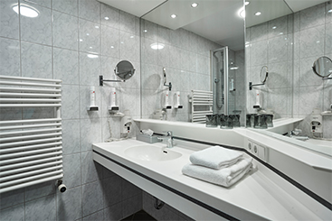 Ein Badezimmer mit Waschbecken, Spiegel und Handtuchhalter.