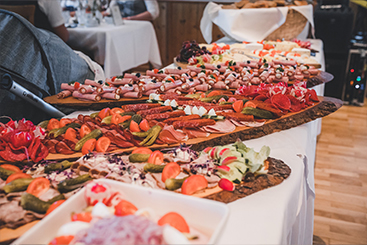 Ein Buffettisch mit einer Vielzahl an Speisen darauf, perfekt für Hochzeitsfeiern.
