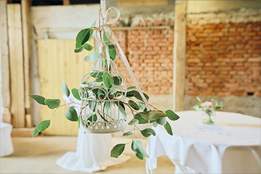 Eine Hochzeitsfeiern mit Grünpflanzen, die von der Decke hängen.